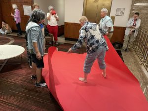 An oversized paper folding team with the gigantic red paper